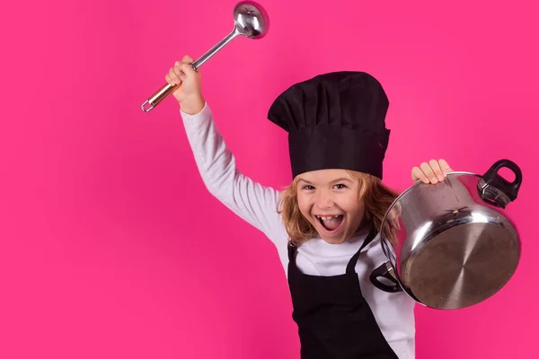 Fynny kid chef cook with cooking pot and ladle. Child chef cook. Child wearing cooker uniform and chef hat preparing food, studio portrait