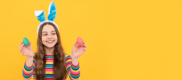she is looking for eggs. funny child hold painted eggs. teenager girl wear rabbit ears. Easter child horizontal poster. Web banner header of bunny kid, copy space
