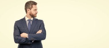 Kendine güvenen ciddi bir patron kollarını resmi takım elbiseyle kavuşturur, profesyonel. İnsan yüzü portresi, fotokopi alanı olan pankart. Takım elbiseli bir iş adamı, izole stüdyo geçmişi var.