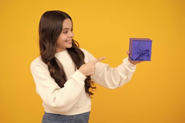 İzole edilmiş arka planda hediye kutusu olan çocuk. Doğum günü hediyeleri, sevgililer günü, yeni yıl ya da Noel. Mutlu yüz, pozitif ve gülümseyen genç kız duyguları