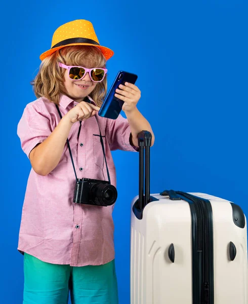 Kids travel. Happy child boy in travel hat with suitcases isolated on studio backgraund. Travel lifestyle and dreams of travel