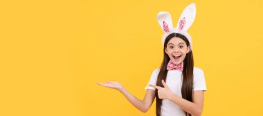 surprised kid girl presenting product or shopping sales. Easter child horizontal poster. Web banner header of bunny kid, copy space