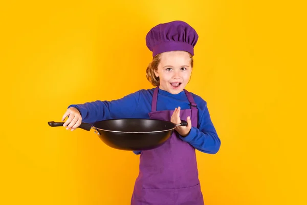 Kid boy chef cook with cooking pan. Chef child preparing healthy food. Studio portrait of child with chef hats