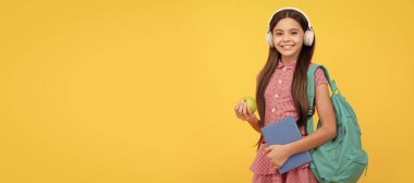 Eğitim konsepti. Öğlen yemeğinde iş kitabı ve elmalı kulaklıklı çocuk. Öğrenci pankartı. Kopya alanı olan öğrenci portresi