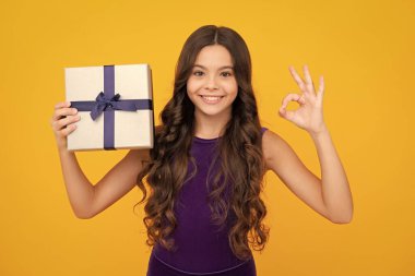 İzole edilmiş arka planda hediye kutusu olan çocuk. Doğum günü hediyeleri, sevgililer günü, yeni yıl ya da Noel. Mutlu kız yüzü, pozitif ve gülümseyen duygular
