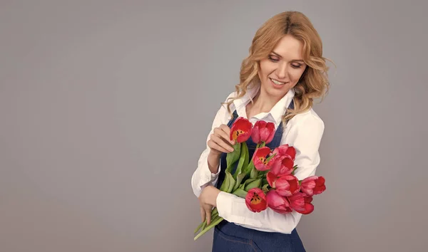 Gri Arka Planda Bahar Lale Çiçekleri Olan Önlüklü Pozitif Kız — Stok fotoğraf