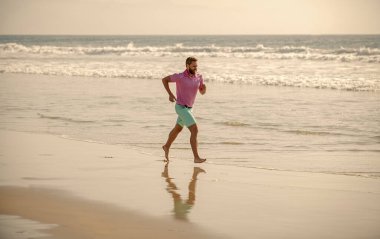 healthy man running on beach. energetic summer. runner feel freedom. enjoying the morning. endurance and stamina. happy sport athlete run fast to win in the ocean. morning workout activity.