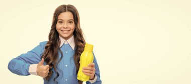 Happy kid give thumbs up hand gesture holding yellow plastic drinking bottle, approval. Horizontal poster of isolated child face, banner header, copy space