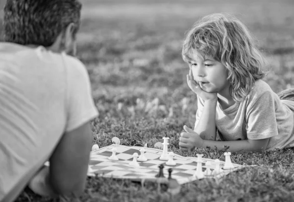 快乐的父子家庭在公园的绿草上下棋 童年时期的发展 — 图库照片