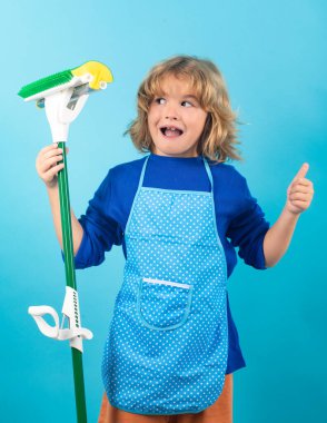 Çocuk ev konseptiyle temizlik yapıyor. Ev işlerine yardım etmek için paspasla çocuk temizliği. Süpürme ve temizlik yapan küçük şirin çocuk, stüdyo renklerinde izole edilmiş.