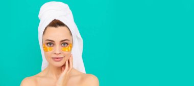 Eye patches, patch under eyes. smiling young woman with golden collagen patch on face skin. Beautiful woman isolated face portrait, banner with mock up copy space