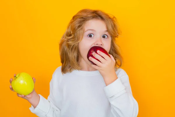 stock image Apples. Kid with apple in studio. Studio portrait of cute child hold apple isolated on yellow background