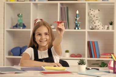 Okul sınıfında kağıt uçakla neşeli çocuk oyunu.