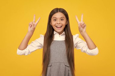 Mutlu kız yüzü, pozitif ve gülümseyen duygular. Sarı arka planda izole edilmiş Ziyaretçi işareti gösteren neşeli genç kız portresi