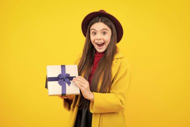 Child with gift present box on isolated background. Presents for birthday, Valentines day, New Year or Christmas. Excited teenager, glad amazed and overjoyed emotions