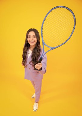 Moda elbiseli genç tenisçi kız izole edilmiş sarı arka planda tenis raketi tutuyor. Tenis okulu