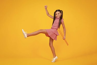 Okul üniformalı kız matematiksel ölçü alıyor. Ölçü ölçümü. Okul ekipmanları. Ergen öğrenci kök disiplini okuyor. Çılgın atlayış, zıplayan çocuklar