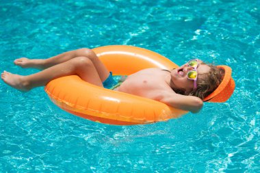 Mutlu çocuk yüzme havuzunda oynuyor. Yaz tatili kavramı. Yaz çocukları sahilde deniz suyunda portre yapar.