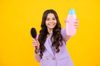 Teenager child girl with bottle shampoo conditioners or shower gel. Kids hair care. Hair cosmetic product, shampoo bottle. Happy face, positive and smiling emotions of teenager girl