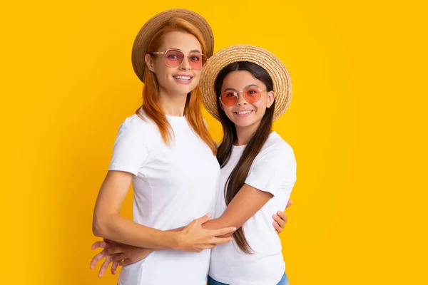 엄마와 대딸은 노란색 배경에 고립된 티셔츠 지푸라기 모자와 선글라스를 상냥하게 — 스톡 사진