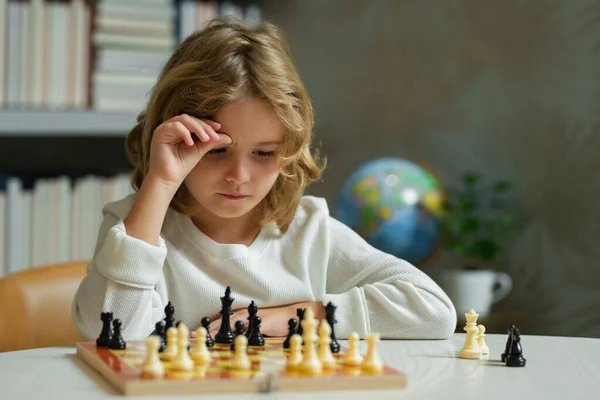 Kid thinking of chess. Chess school. Kid think about chess game. Child education concept. Intelligent, smart and clever school kids