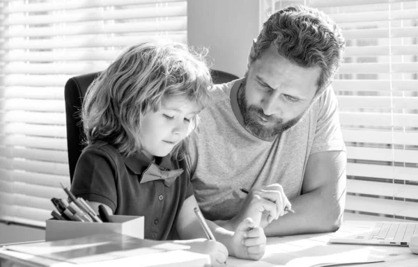 drawing lesson. education. homeschooling and painting. back to school. concentrated father and son writing at home. family and parenthood blog. boy do homework with private teacher.