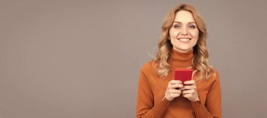 Mutlu kadın mesajları internet üzerinden akıllı telefon iletişimi gri arka planda sohbet ediyor. Kadın portresi, kopyalanmış başlık pankartı