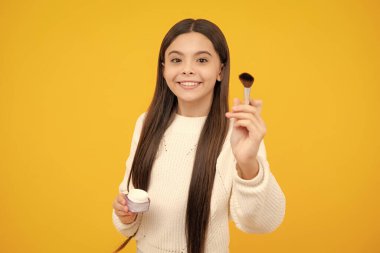 12, 13, 14 yaşlarında pudra ve fırçayla güzellik yapan bir kız çocuğu. Makyaj yapan güzel genç.