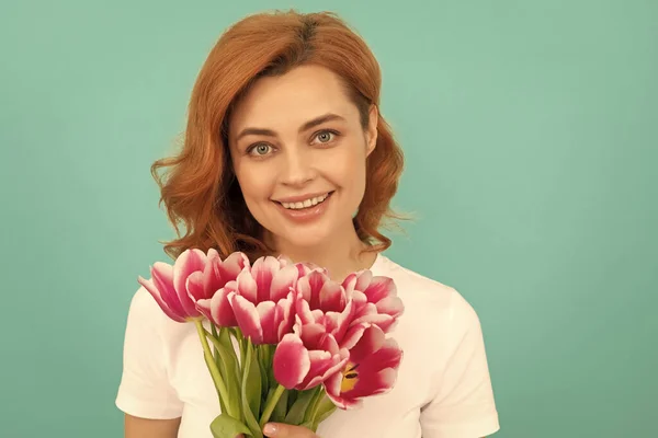 happy woman with tulip flower bouquet on blue background. mothers day.