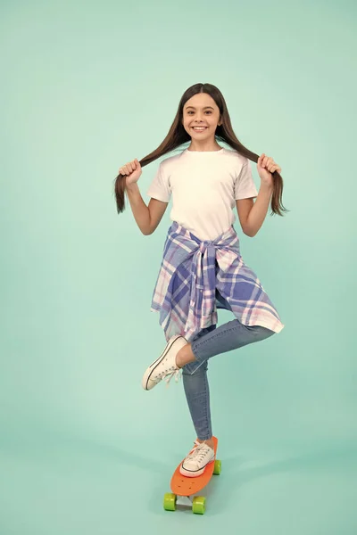stock image Teen school girl with skateboard on studio isolated background. Schoolgirl spring trend, urban teenager style. Happy teenager, positive and smiling emotions of teen girl