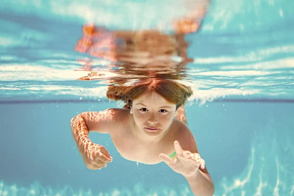 子供は水泳プールで水中で泳いだり潜水したり — ストック写真