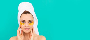 Güzel yüzlü kadın, yüz portresi. Yüzünde altın kolajen bandı olan genç bir kadın. Güzel kadın, izole edilmiş yüz portresi, taklit alanı olan pankart.