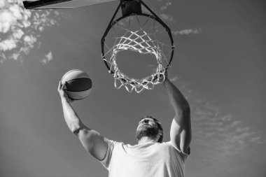 muscular man player throw basketball ball through basket, male basketball.