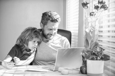 Mutlu öğretmen oğluna yazı ve dizüstü bilgisayarda yardım ediyor, okula geri dönüyor..