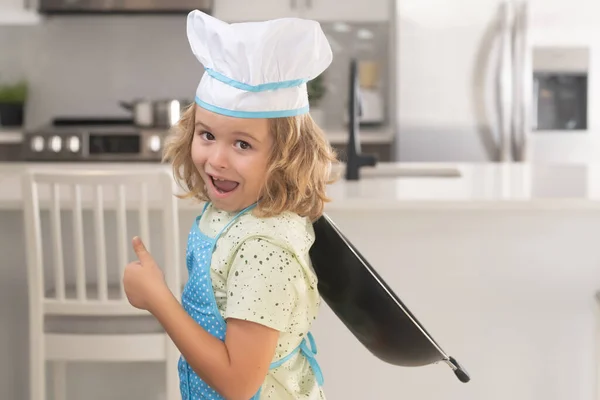 面白い小さな子供のシェフは キッチンで均一な調理キャップとエプロン調理食品を身に着けて調理します 子供たちは生地を準備しています キッチンでクッキーを焼く — ストック写真