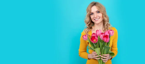 Mavi Arka Planda Bahar Lale Çiçekleri Olan Mutlu Sarışın Kadın — Stok fotoğraf
