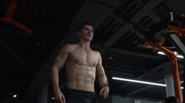 Spor salonunda atlayan kaslı bir adam. Spor salonunda kaslı adam ısınıyor. Kaslı adamın spor ısınması.