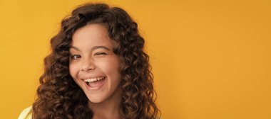 happy winking teen girl with long curly hair and perfect skin, frizzy. Child face, horizontal poster, teenager girl isolated portrait, banner with copy space