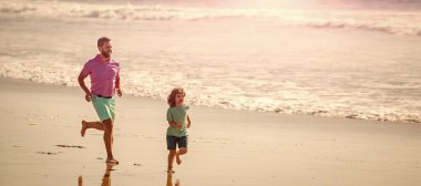 Banner of father and son run on summer sea beach. father and son running on summer beach with water, family.