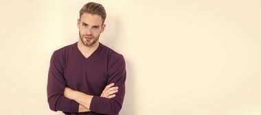 Kendinden emin ve rahat hissediyorum. Kendine güvenen bir adam kollarını çapraz olarak beyazın üzerinde tutar. Sıradan bir tarz. İnsan yüzü portresi, kopyalama alanı olan pankart