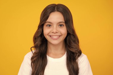 Gençlik gününde kameraya gülümseyen bir kızın hayat tarzı portresi. Mutlu çocuklar günü.