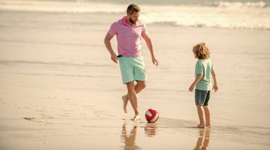 Babalar Günü 'nde plajda top oynayan baba-çocuk pozitif bir aile..