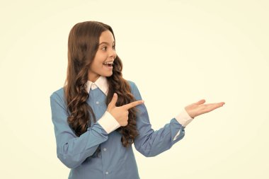 amazed child long curly hair isolated on white presenting product and pointing finger on copy space, advertisement.