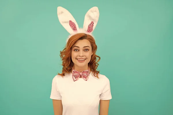 Stock image cheerful easter girl in bunny ears and bow tie on blue background.