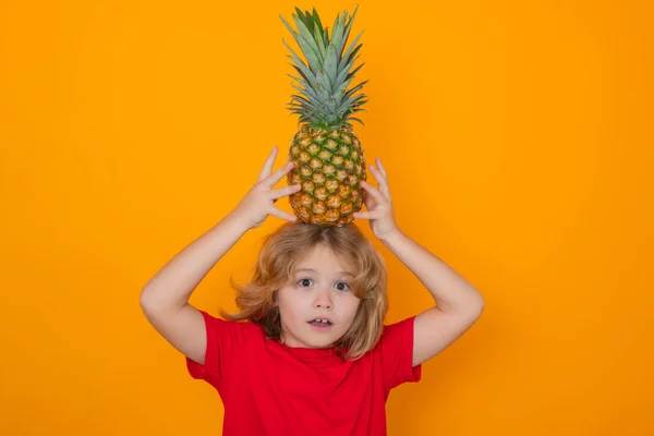 stock image Kid with pineapple in studio. Studio portrait of cute child hold pineapple isolated on yellow background