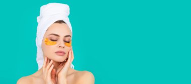 Hanımefendinin yüzünde havluyla kolajen altın göz bantları var. Güzel kadın, izole edilmiş yüz portresi, taklit alanı olan pankart.