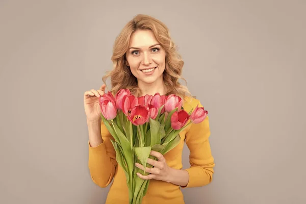 Mutlu Kadın Bahar Tatili Için Çiçekleri Gri Arka Planda Tutar — Stok fotoğraf