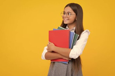 Okula dönelim. Kitabı öğrenmeye hazır ergen bir kız öğrenci. İzole edilmiş sarı stüdyo geçmişi olan liseli kızlar. Mutlu kız yüzü, pozitif ve gülümseyen duygular