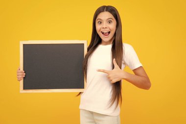 Genç kız çocuğu tahtayı tutuyor. Elinde boş tebeşir tahtası tutan ilkokul öğrencisi kız. Uzayı kopyala, taklit pankartı. Heyecanlı bir genç, şaşkın ve neşeli duygular içinde