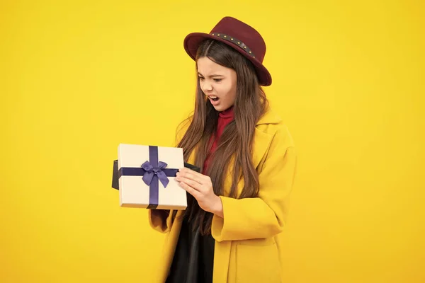 stock image Emotional teenager child hold gift on birthday. Funny kid girl holding gift boxes celebrating happy New Year or Christmas. Angry face, upset emotions of teenager girl